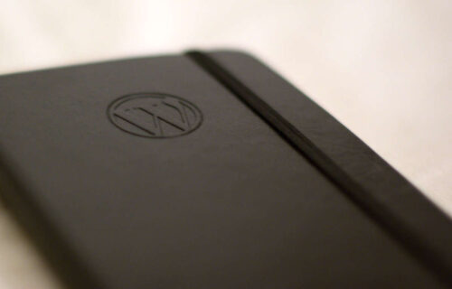 A brown notebook with the WordPress logo in the cover.