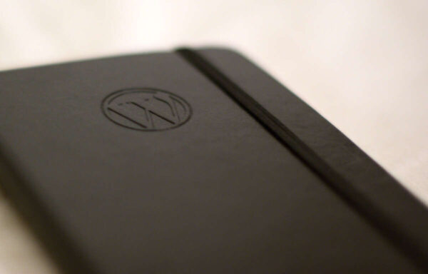 A brown notebook with the WordPress logo in the cover.